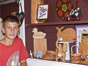 Isaiah shows off his work on display at the Jelly Bean Tree artisans' cooperative. “I saved up enough to buy a professional Hawk G4 26-inch scroll saw,” Isaiah said. “It was the newest model Hawk had available.  I don’t go off of the lines much anymore.”  “I saved up enough to buy a professional Hawk G4 26-inch scroll saw,” Isaiah said. “It was the newest model Hawk had available.  I don’t go off of the lines much anymore.”  