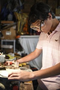 Logan Leppo ’17 uses a band saw to cut one-inch thick pieces of pine for a toy dog.