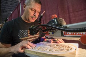 Lee McCartney demonstrates scroll sawing in his booth. Photo by Marc Featherly.